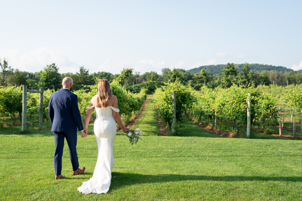 Bride and groom walking through a vineyard at golden hour during their Atlanta wedding.