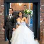 Bride and groom joyfully entering reception together.