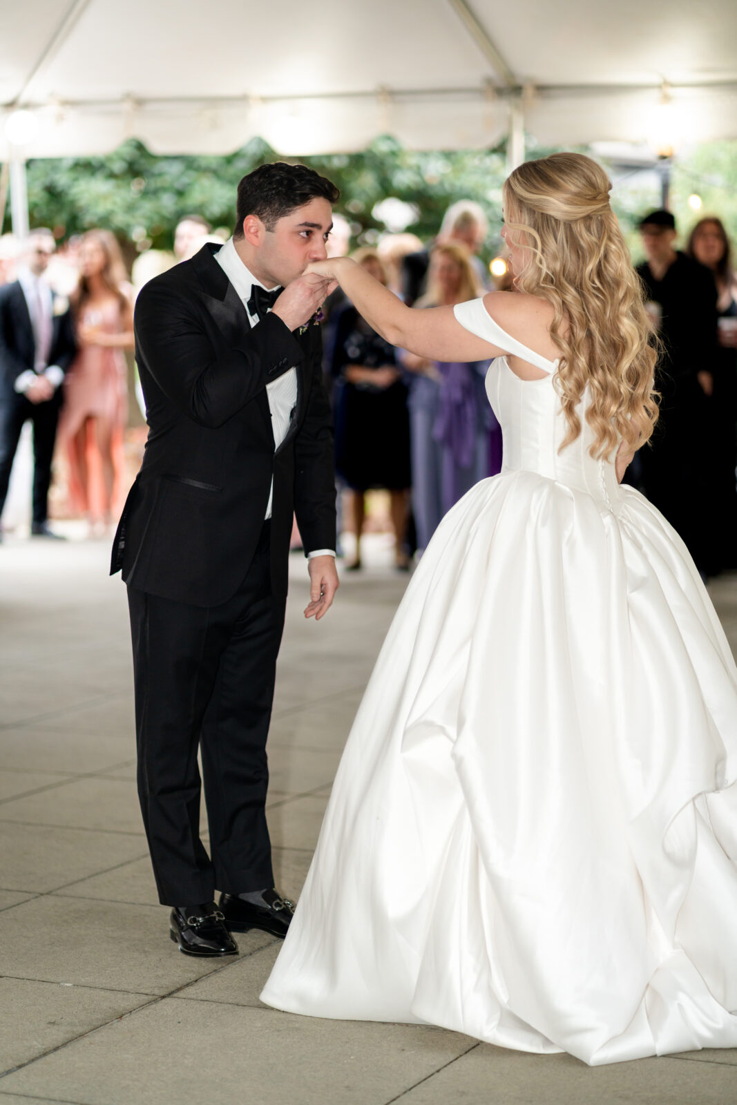 Groom sweetly kissing bride’s hand during their first dance at 173 Carlyle House