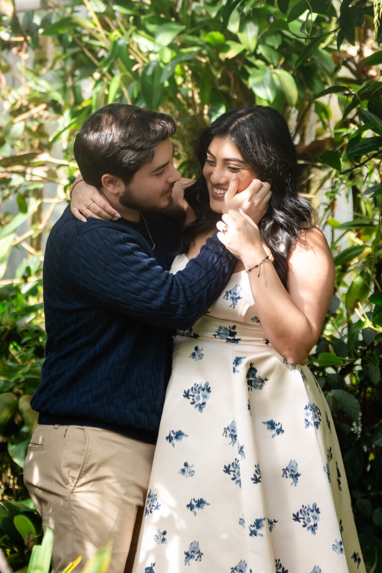 Newly engaged couple embracing in lush garden after surprise proposal