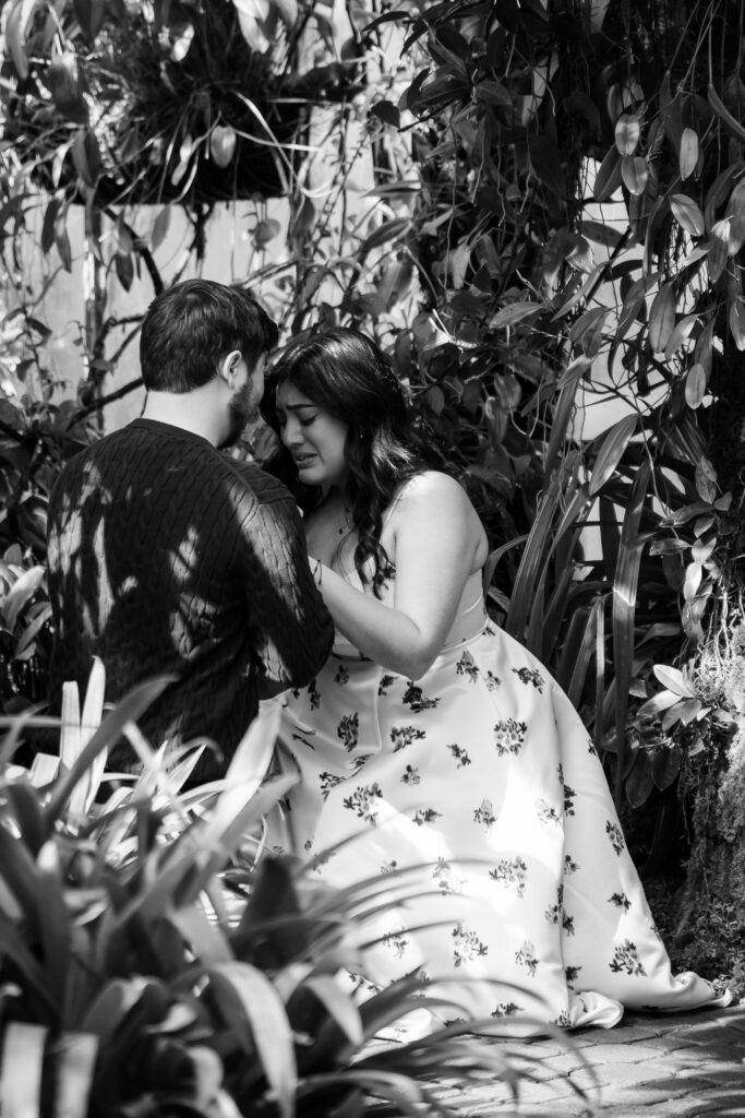 Emotional moment during surprise proposal in the botanical garden