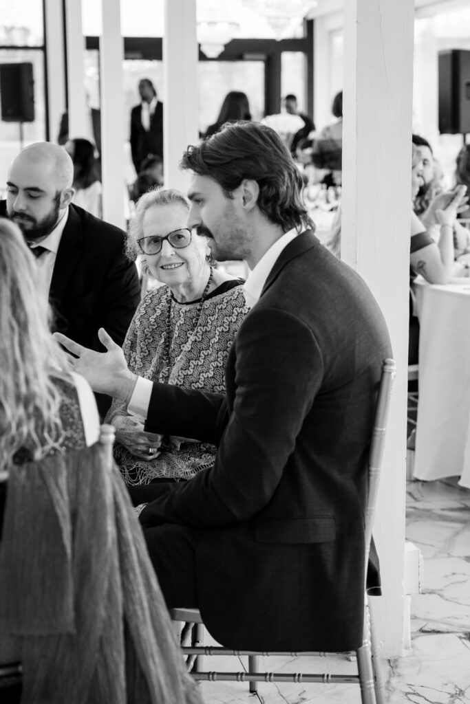 Wedding guest shares a warm conversation with family during the Chateau 1800 reception.
