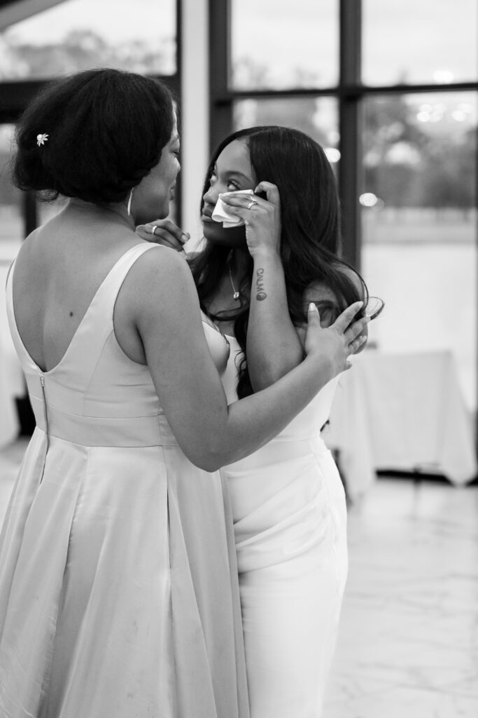 The bride wipes away tears during an emotional moment with her mom at Chateau 1800.