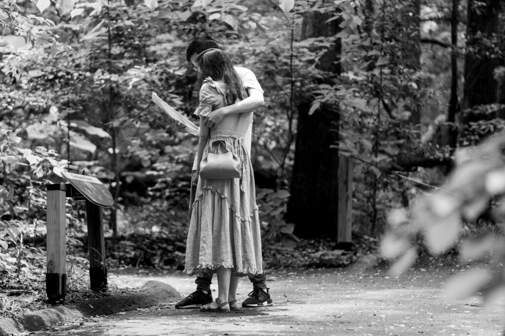 Couple hugging while reading letter before proposal in Fernbank Forest