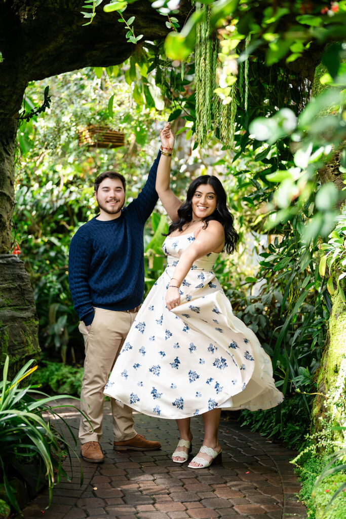 Joyful couple dancing in Atlanta Botanical Gardens after proposal by Kalyn Wolf Studios