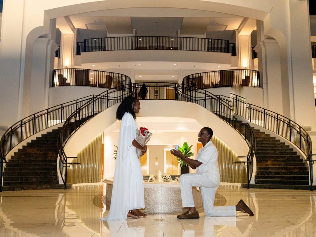 Romantic marriage proposal in front of grand staircase captured by Kalyn Wolf Studios