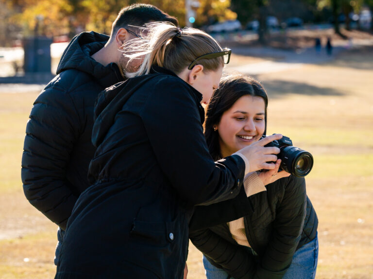 Photographer showing the couple their photos on the back of the camera after a Piedmont Park proposal session in Atlanta.