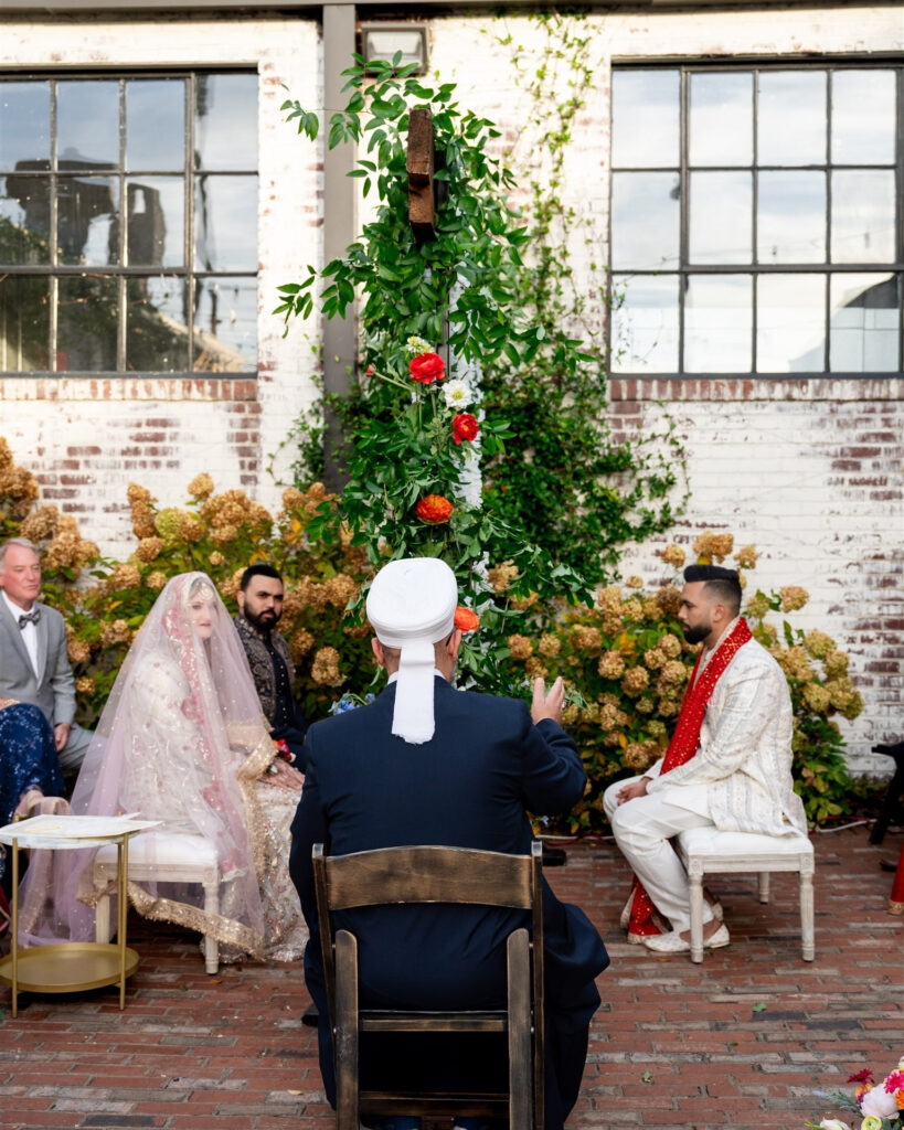 A look at the couple sitting down at a ceremony designed by an Indian wedding planner in Atlanta. 