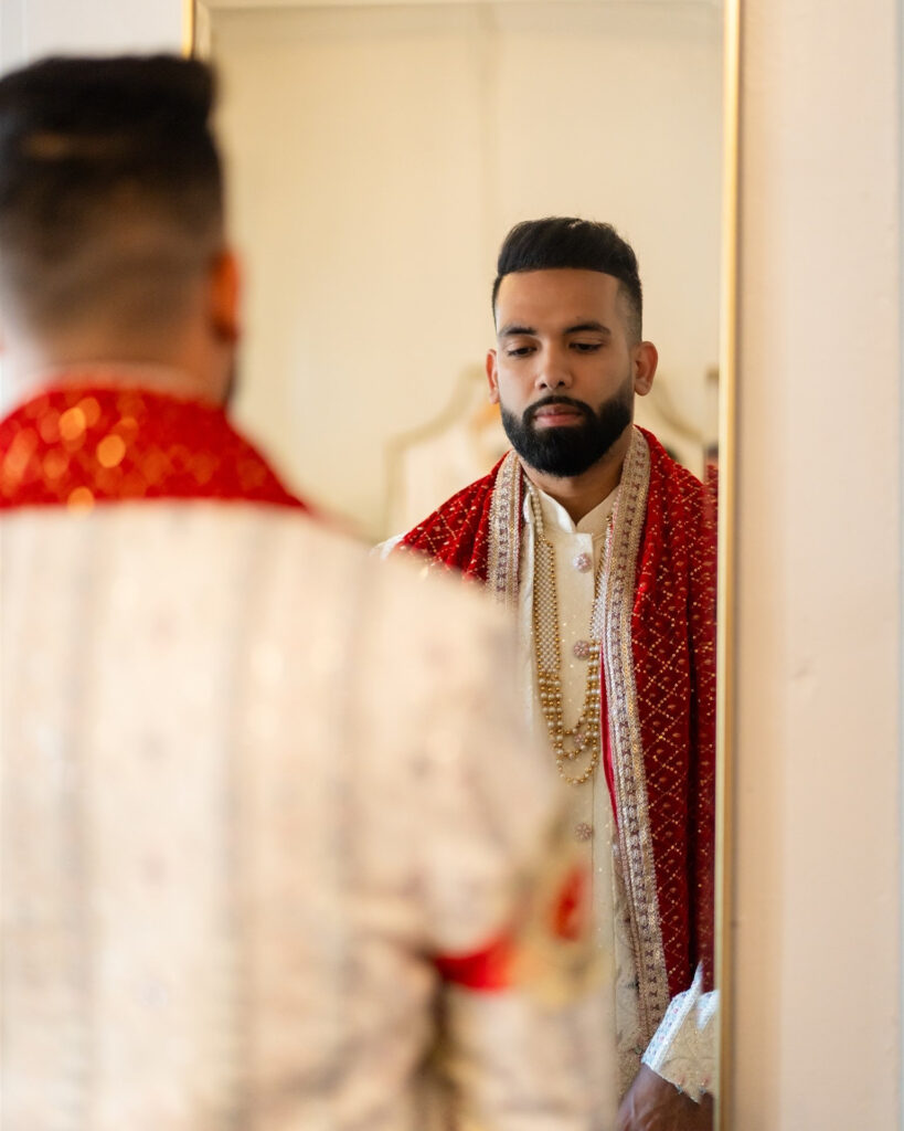 Groom prepares in emotional moment preserved by Indian wedding photographers. 