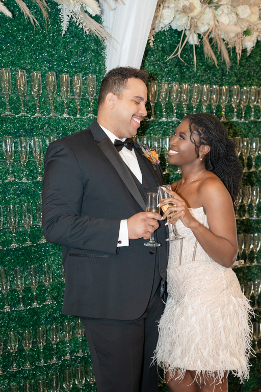 Bride and groom smile at each other after getting married in Georgia while holding champagne glasses