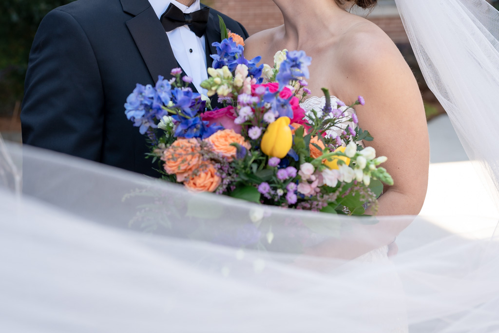 Bride and groom hold bouquet of colorful flowers after getting married in Georgia