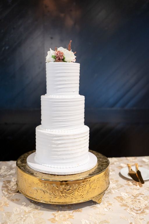 A three tier white wedding cake at a reception after getting married in Georgia