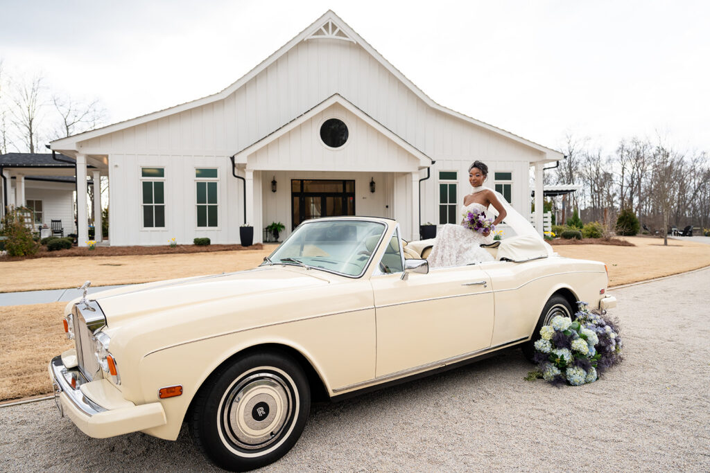 Georgia Wedding Photography | Kalyn Wolf Studios Bride posing in a vintage convertible outside a venue during a Georgia wedding photography session.