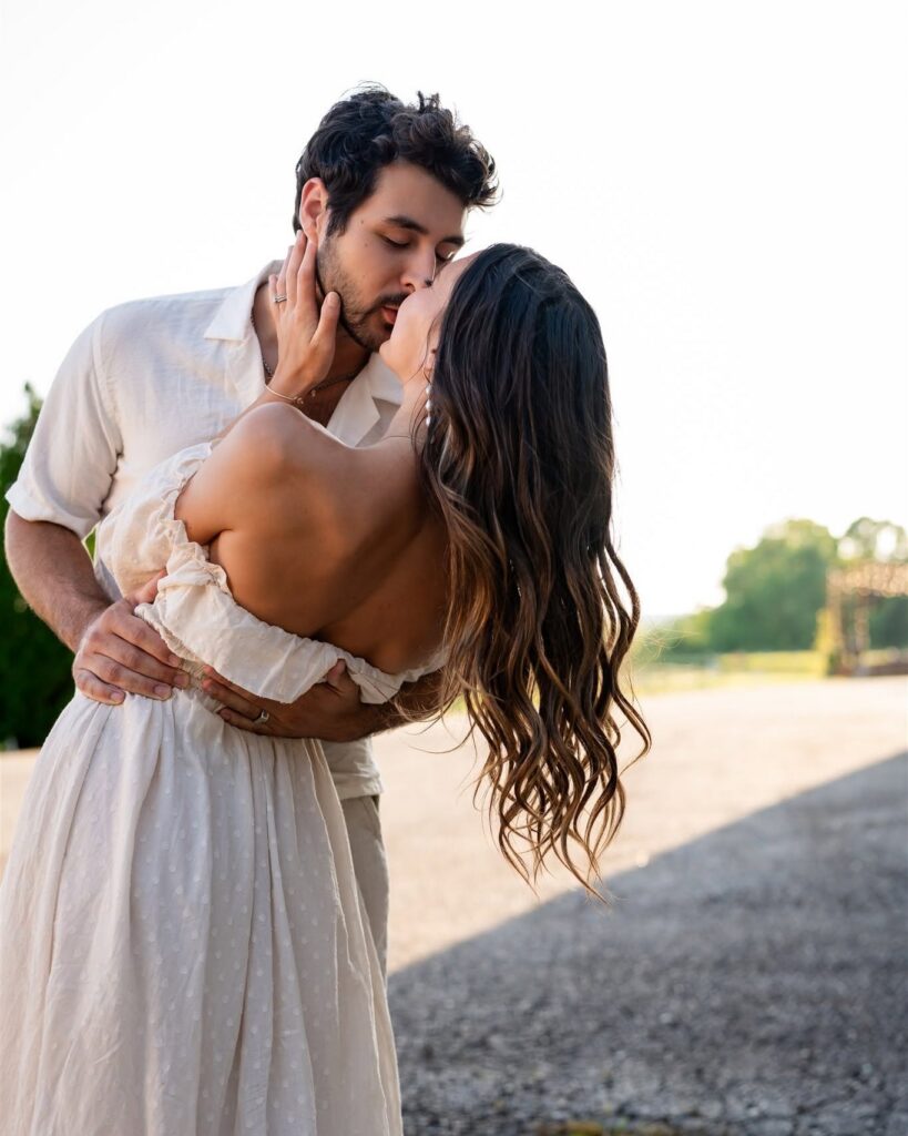 Romantic engagement photo of a couple kissing at Montaluce Winery, one of the best places to take engagement photos in Georgia.