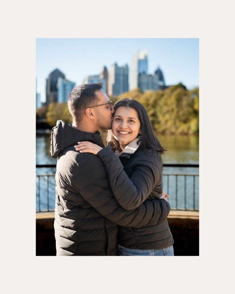 Couple embracing during an engagement session near the Atlanta skyline, showcasing one of the many engagement photo locations in North Georgia.